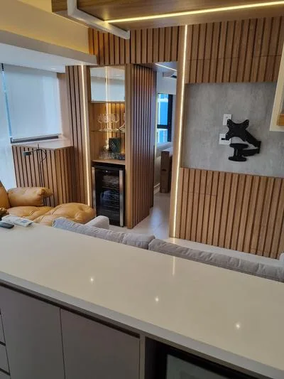 Studio Pinheiros: sala com painel ripado e adega