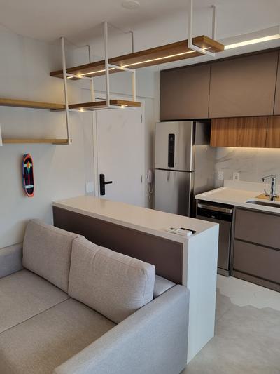 Studio Pinheiros — sala com sofá e iluminação